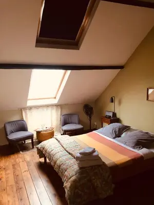 a bedroom with a bed and two chairs and a skylight at B&B Faja lobi in Ghent