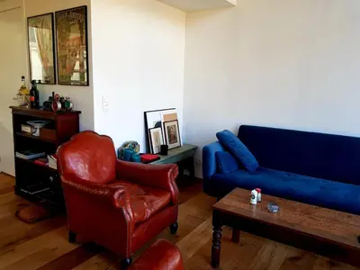 a living room with a blue couch and a chair at Perfect location & Parking in Antwerp