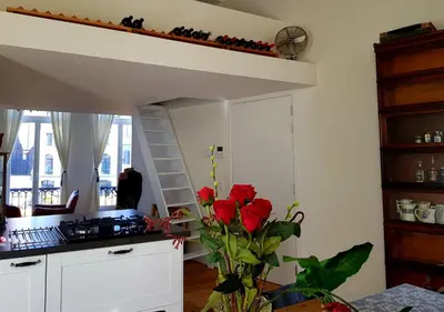 a kitchen with a loft bed and red roses at Perfect location & Parking in Antwerp