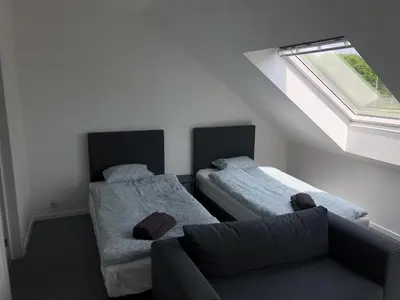 a room with two beds and a couch and a window at Apartment Brussels Airport and NATO OTAN in Machelen