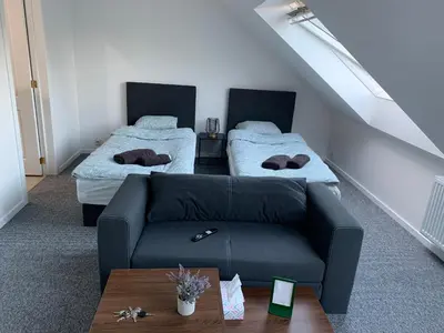 a living room with a couch and two beds at Apartment Brussels Airport and NATO OTAN in Machelen