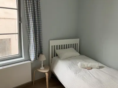 a small bedroom with a bed and a window at La Maison des Sources in Brussels