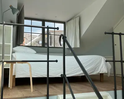 a bedroom with a bed and a window at La Maison des Sources in Brussels