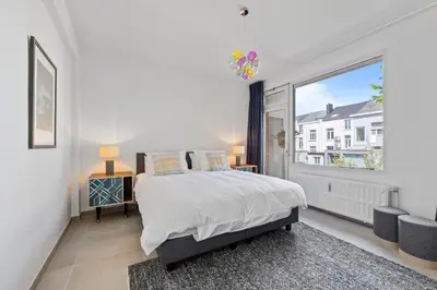a bedroom with a bed and a large window at Central & luminous apartment in Antwerp