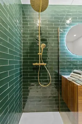 a bathroom with a shower with green tiles at Central & luminous apartment in Antwerp
