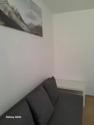 a couch in a room with a painting on the wall at 1 bedroom studio sleeps 4 in Brussels