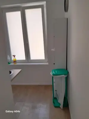 a room with three windows and a green stool at 1 bedroom studio sleeps 4 in Brussels