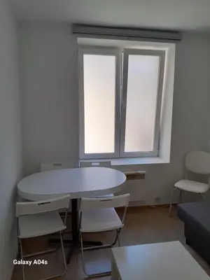 a living room with a table and two windows at 1 bedroom studio sleeps 4 in Brussels