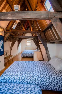 a bedroom with a blue bed in a attic at Unieke woning in het historisch stadscentrum in Antwerp