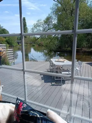 a view from a window of a deck with a table at Time 2 Relax chalet aan het water in Geel