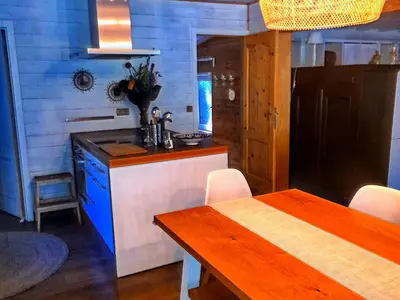 a kitchen with a table and a blue wall at Oud-Turnhout Nature Chalet in Oud-Turnhout