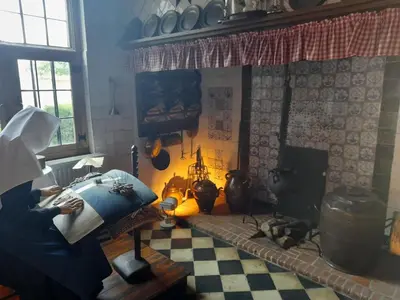 a woman reading a book in a living room with a fireplace at Oud-Turnhout Nature Chalet in Oud-Turnhout