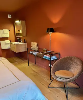 a room with a bed and a chair and a table at Domaine Bourgogne en Grez 