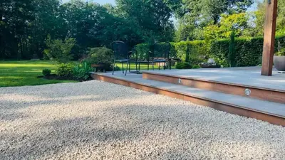 a patio with gravel and a table in a garden at Domaine Bourgogne en Grez 