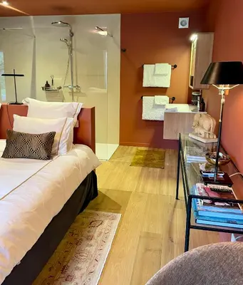 a bedroom with a bed and a glass table at Domaine Bourgogne en Grez 