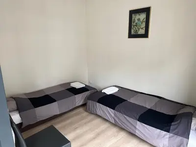 two beds in a small room with a picture on the wall at 3 Bedroom Apartment in City Center with Balcony View in Brussels