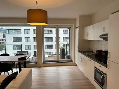 a kitchen and dining room with a table and a view of a building at 3 Bedroom Apartment in City Center with Balcony View in Brussels
