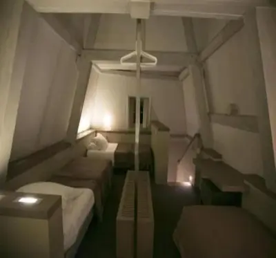 a room with two beds and a ceiling fan at Gravenhof in Beersel