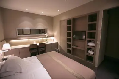 a bedroom with a bed and a desk and a kitchen at Gravenhof in Beersel