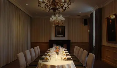 a dining room with a long table and white chairs at Gravenhof in Beersel