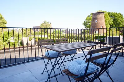 a picnic table and chairs on a balcony with a fence at Apartment with a view and parking in Brecht
