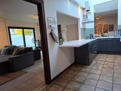 a kitchen and a living room with a couch at De Volkswasserij, woning met tuin in Leuven