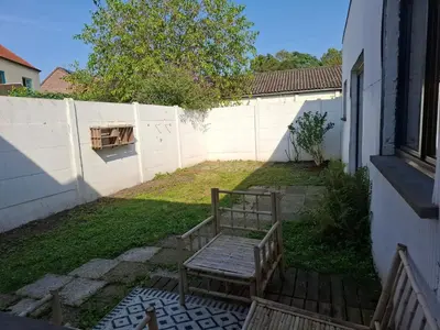 a bench sitting in a yard next to a fence at De Volkswasserij, woning met tuin in Leuven