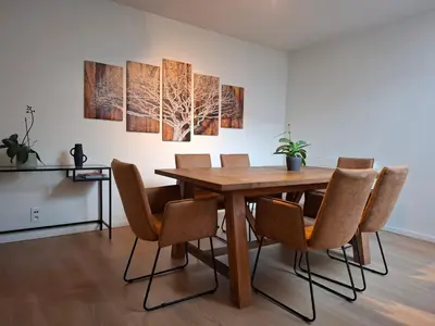 a dining room with a wooden table and chairs at De Volkswasserij, woning met tuin in Leuven