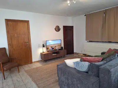 a living room with a couch and a flat screen tv at De Volkswasserij, woning met tuin in Leuven