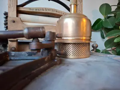 a metal object sitting on top of a sewing machine at De Volkswasserij, woning met tuin in Leuven
