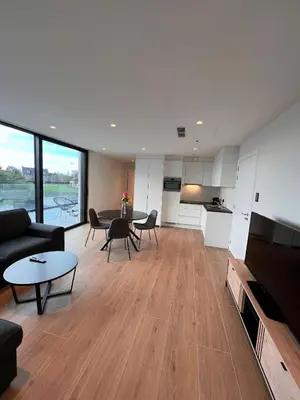 a living room with a couch and a table with chairs at ApartHotel Dénia in Lochristi