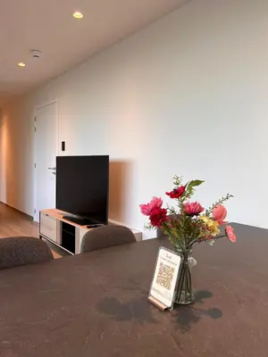 a vase of flowers sitting on a table with a tv at ApartHotel Dénia in Lochristi