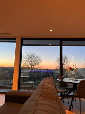 a living room with a couch and a large window at ApartHotel Dénia in Lochristi