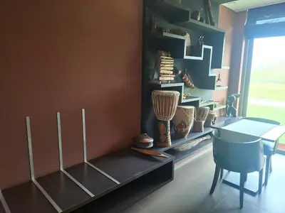 a dining room with a table and a shelf with vases at B&B Finis terrae in Lokeren