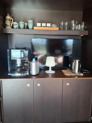 a desk with a tv and a lamp and a computer at B&B Finis terrae in Lokeren