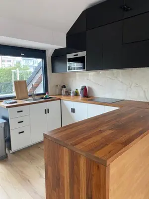 a kitchen with white cabinets and a wooden counter top at Spacious app/Antwerp city center #003 in Antwerp