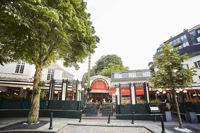a city street with buildings and trees and a gate at Bruxelles in Brussels