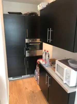a kitchen with black cabinets and a microwave at Bruxelles in Brussels