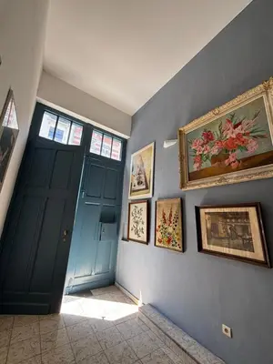 a hallway with a blue door and paintings on the wall at L&L Residence 1 in Brussels