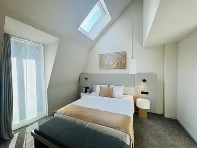 a bedroom with a large bed and a window at OPO Hotel in Brussels