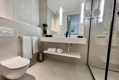 a white bathroom with a sink and a toilet at OPO Hotel in Brussels