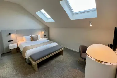 a bedroom with a bed and a table and skylights at OPO Hotel in Brussels