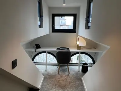 a room with a desk with a chair and a window at OPO Hotel in Brussels