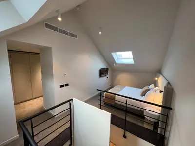 a loft bedroom with a bed and a staircase at OPO Hotel in Brussels
