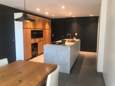 a kitchen with a counter top and a table at landelijke villa met zwembad en gezellige openhaard in Zemst
