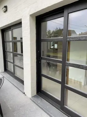 a black door with glass windows on a building at House Botanique in Meise