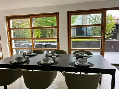 a dining room with a table and chairs and windows at House Botanique in Meise