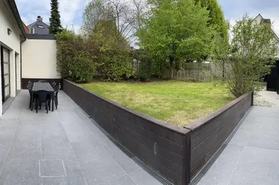 a fence with a table and chairs in a yard at House Botanique in Meise