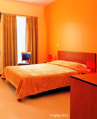 a bedroom with a bed and a chair and a window at Hotel The Moon in Brussels