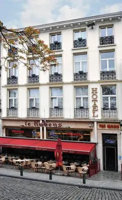 a large white building with tables in front of it at Hotel The Moon in Brussels